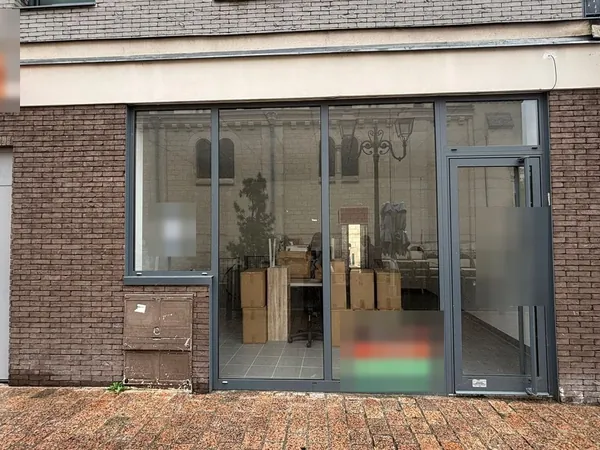 Avant : la façade d'origine en brique avec vitrine aluminium